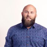 Portrait of Luke Blincoe, Electric Kiwi CEO, in a dark button-up long sleeve shirt.