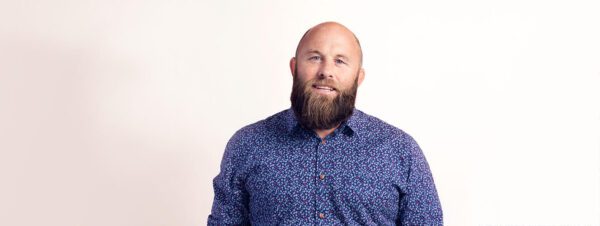 Portrait of Luke Blincoe, Electric Kiwi CEO, in a dark button-up long sleeve shirt.